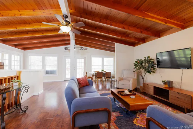 a living room with furniture a flat screen tv and a table