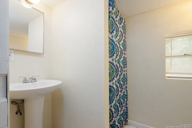 a bathroom with a sink a mirror and a shower