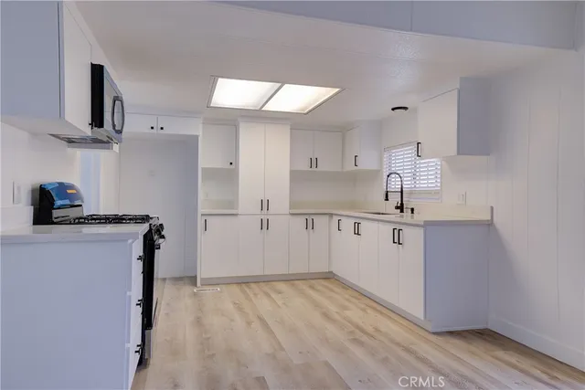 a kitchen with cabinets and wooden floor