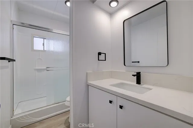 a bathroom with a sink a mirror and shower