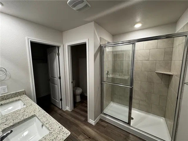 a bathroom with a granite countertop sink and shower