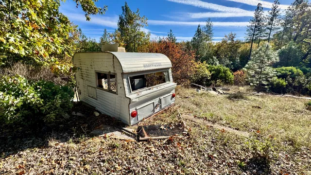 a view of a chairs and table in the backyard with wooden fence