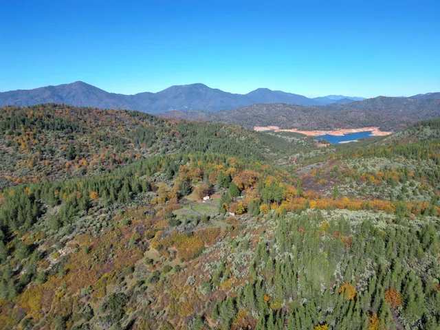 a view of a mountain range with lush green forest