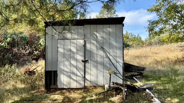 a yellow house with trees in the background