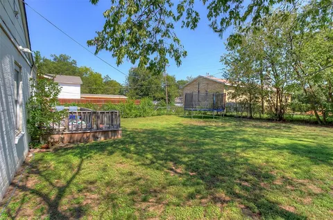 a view of a house with a big yard and large trees