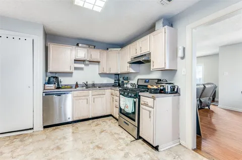 a kitchen with stainless steel appliances granite countertop a refrigerator sink and white cabinets