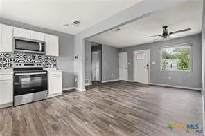 a view of an empty room with a fireplace and a window