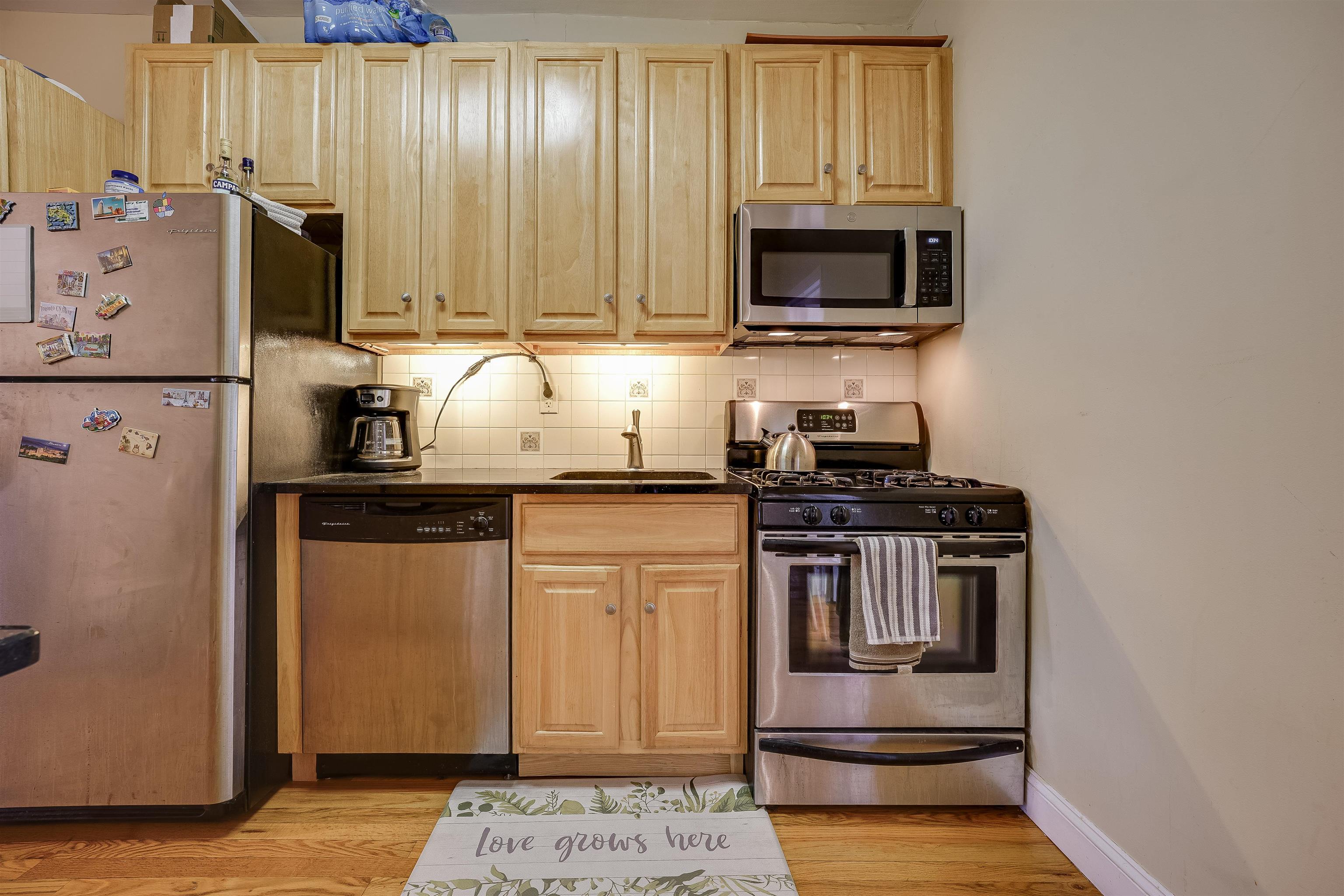 a kitchen with stainless steel appliances granite countertop a refrigerator stove and sink