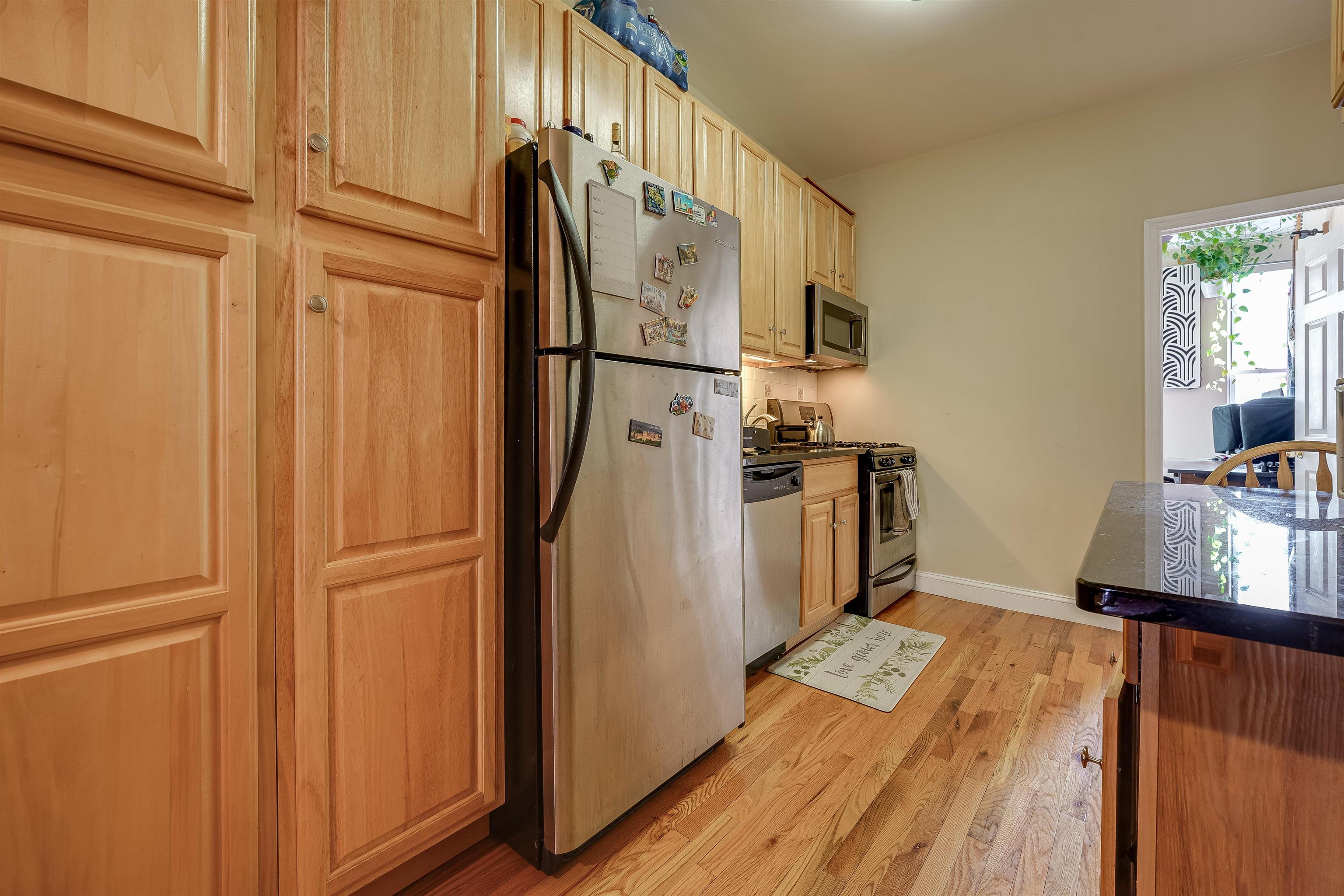 63 Madison Street, Unit 3 Hoboken, NJ 07030 - Photo 11 of 19 a view of a kitchen with wooden floor and electronic appliances