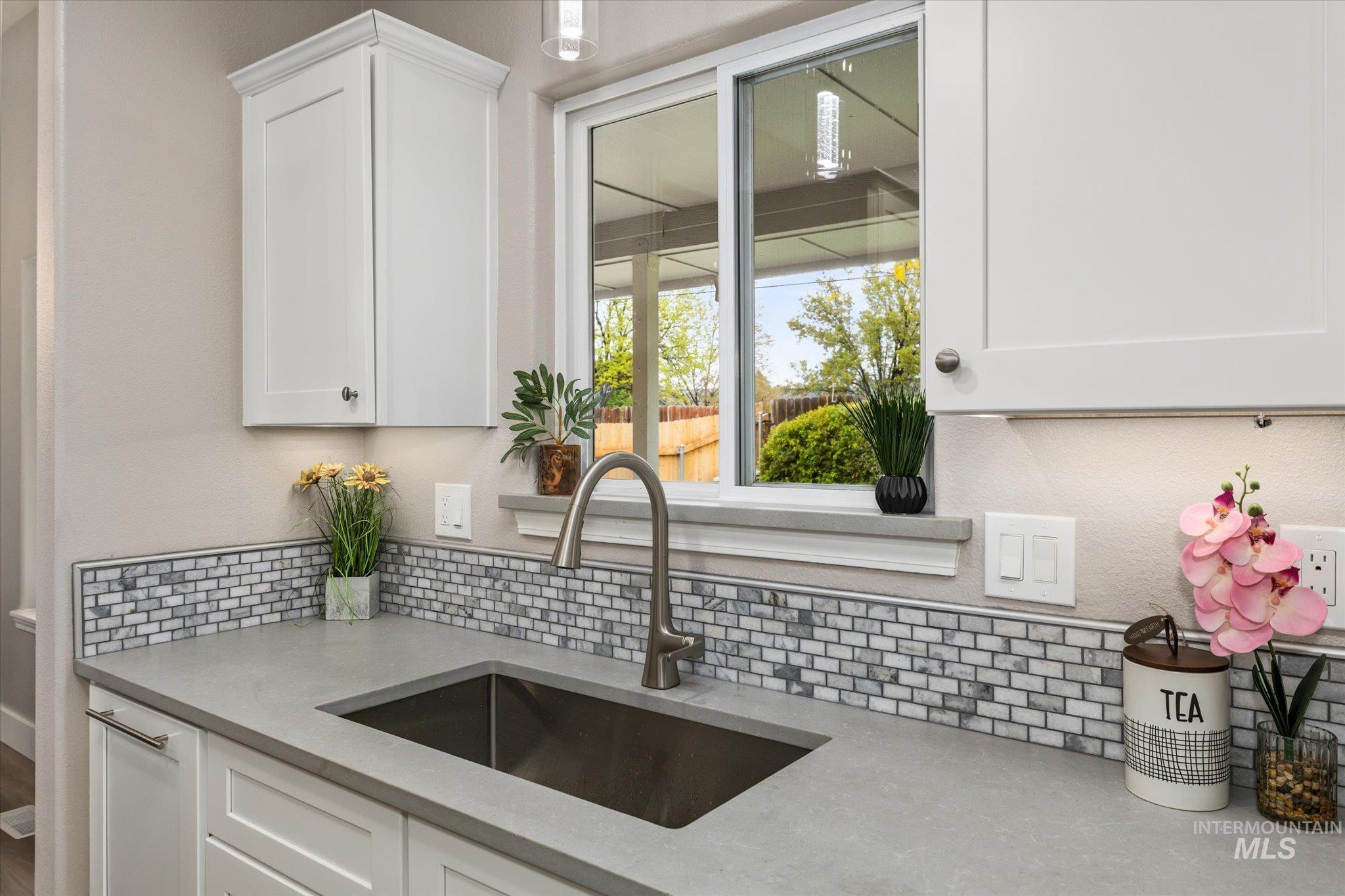 2250 North Amethyst Avenue Meridian, ID 83646 - Photo 17 of 50 Kitchen featuring white cabinetry, light stone counters, and decorative backsplash