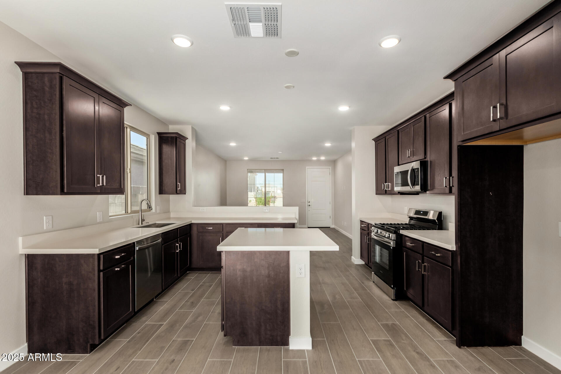 16977 West Spur Drive Surprise, AZ 85387 - Photo 11 of 30 a large kitchen with stainless steel appliances lots of counter space and wooden floor