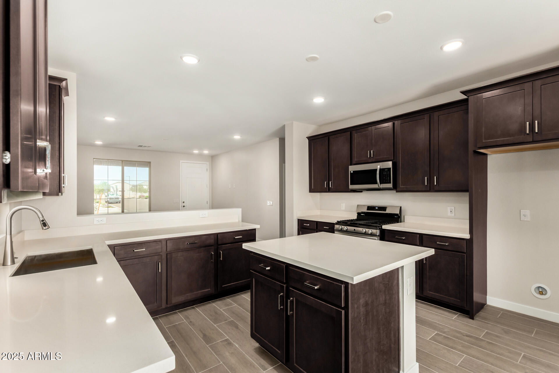 16977 West Spur Drive Surprise, AZ 85387 - Photo 12 of 30 a kitchen with a sink a stove top oven and wooden floors