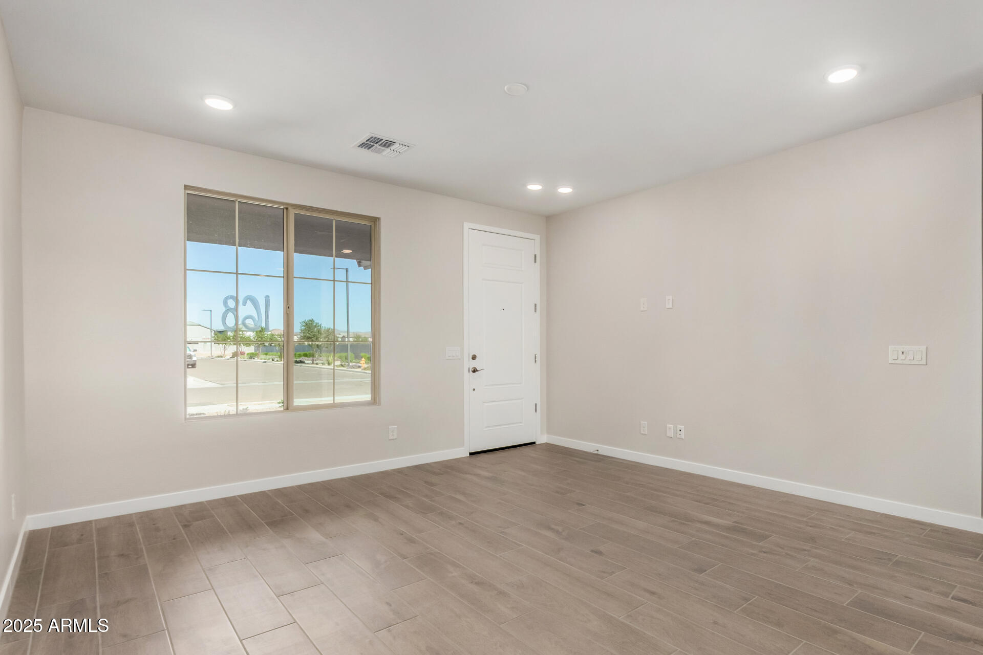 16977 West Spur Drive Surprise, AZ 85387 - Photo 5 of 30 an empty room with wooden floor and windows