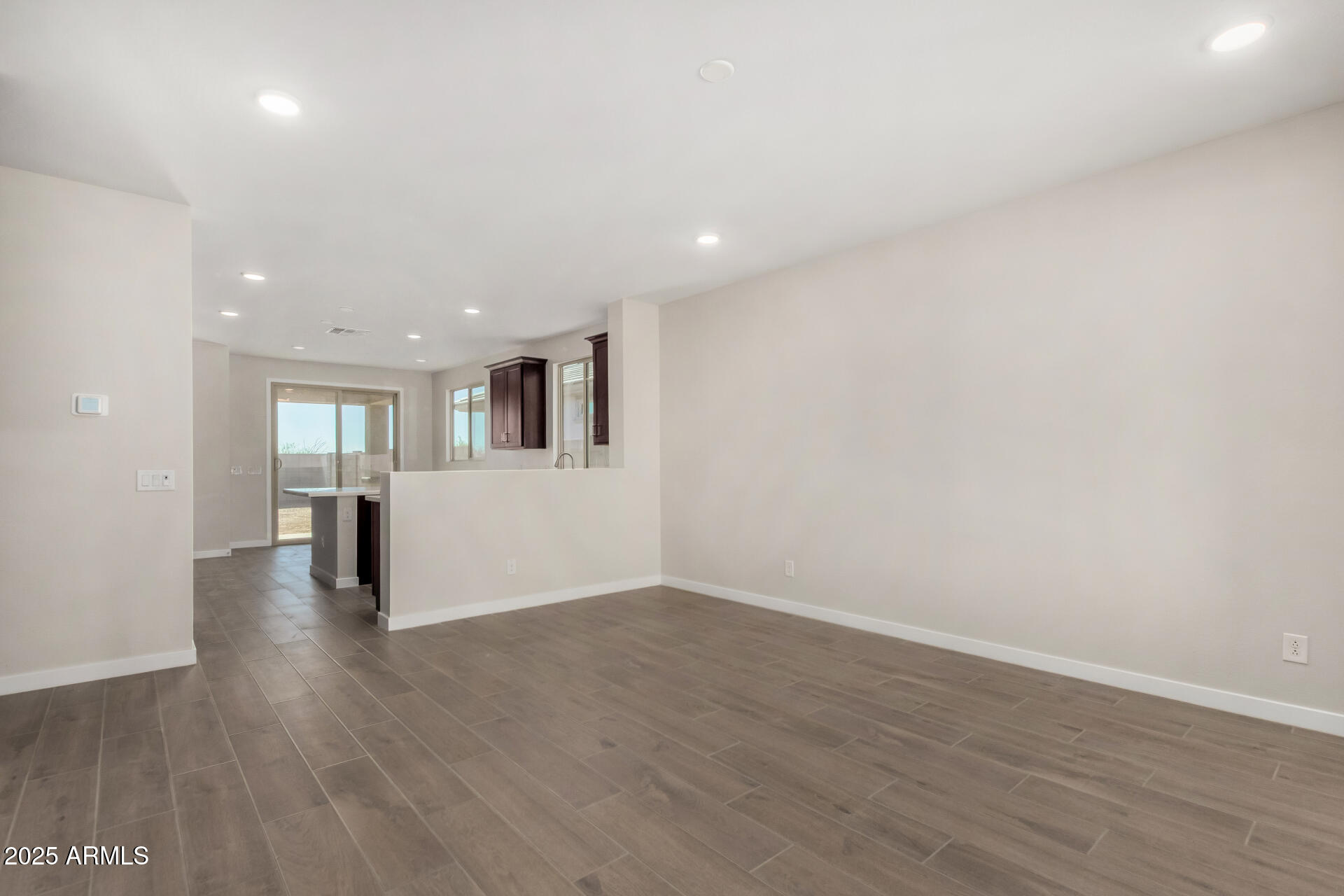 16977 West Spur Drive Surprise, AZ 85387 - Photo 6 of 30 a view of a big room with wooden floor and a kitchen