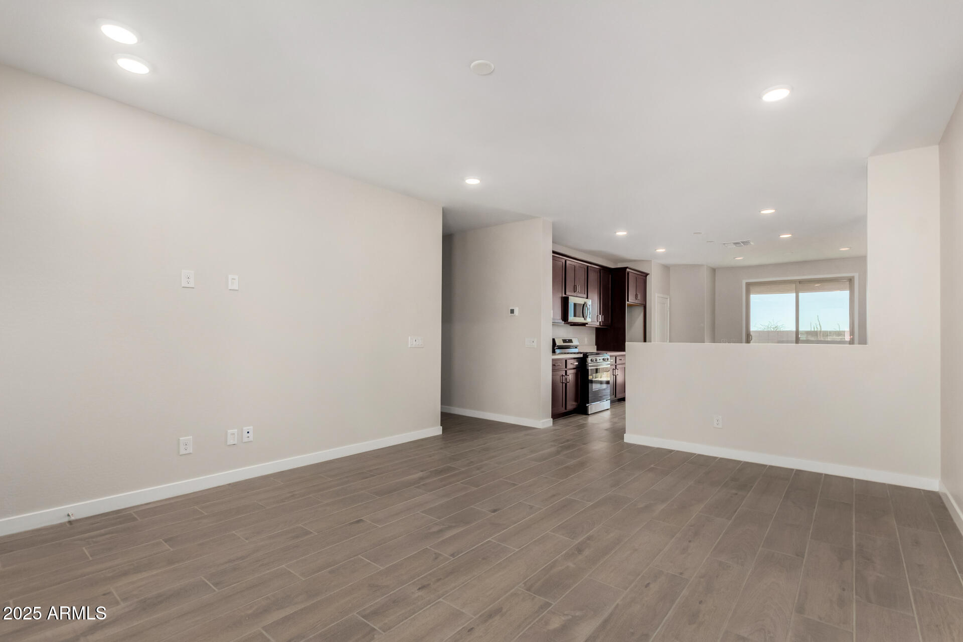16977 West Spur Drive Surprise, AZ 85387 - Photo 7 of 30 an empty room with wooden floor and windows