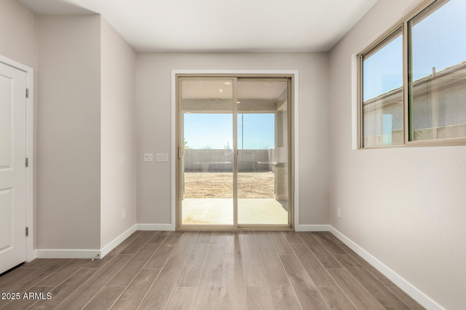 16977 West Spur Drive Surprise, AZ 85387 - Photo 8 of 30 a view of an empty room with wooden floor and a window