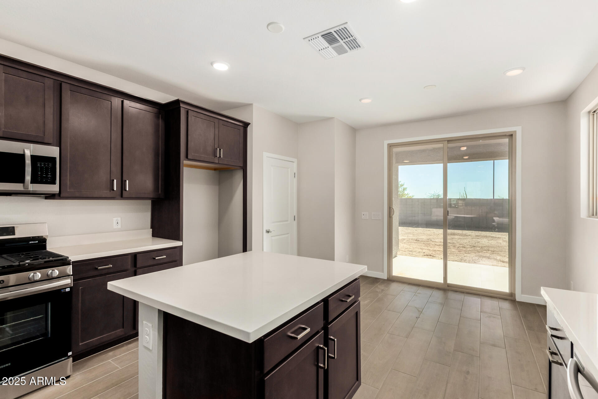 16977 West Spur Drive Surprise, AZ 85387 - Photo 9 of 30 a kitchen that has a cabinets wooden floor and stainless steel appliances