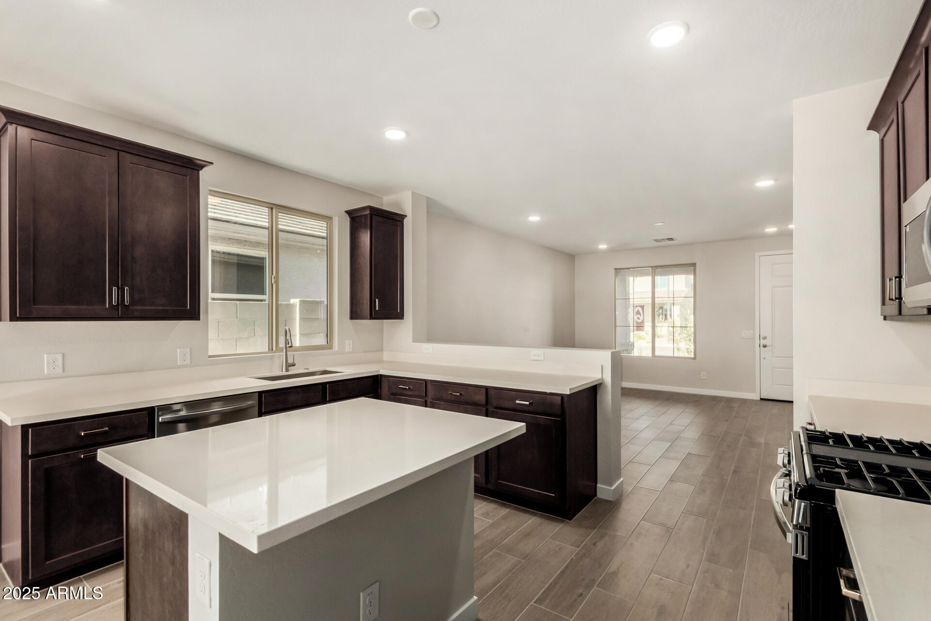 16977 West Spur Drive Surprise, AZ 85387 - Photo 10 of 30 a kitchen with a sink and a stove top oven with wooden floor