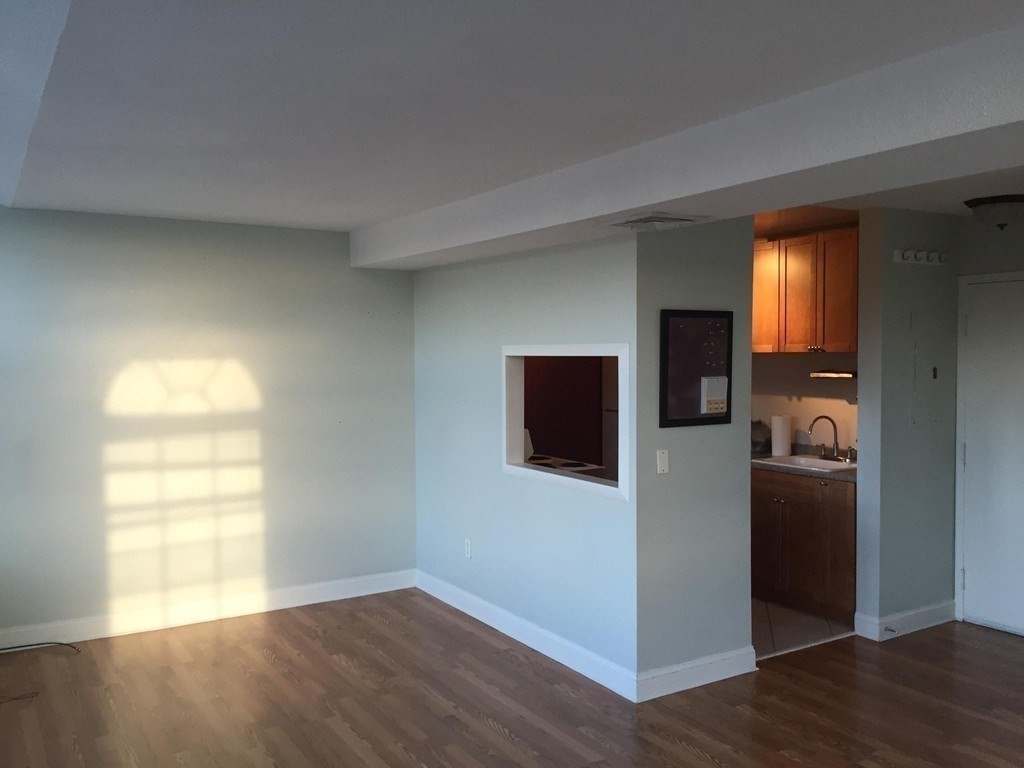 a view of a livingroom with wooden floor and a window