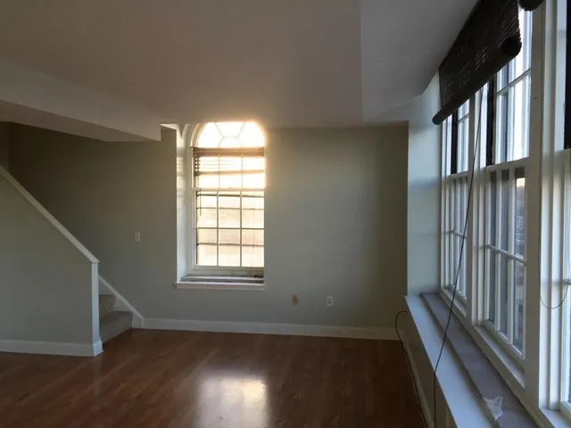 an empty room with wooden floor and a window