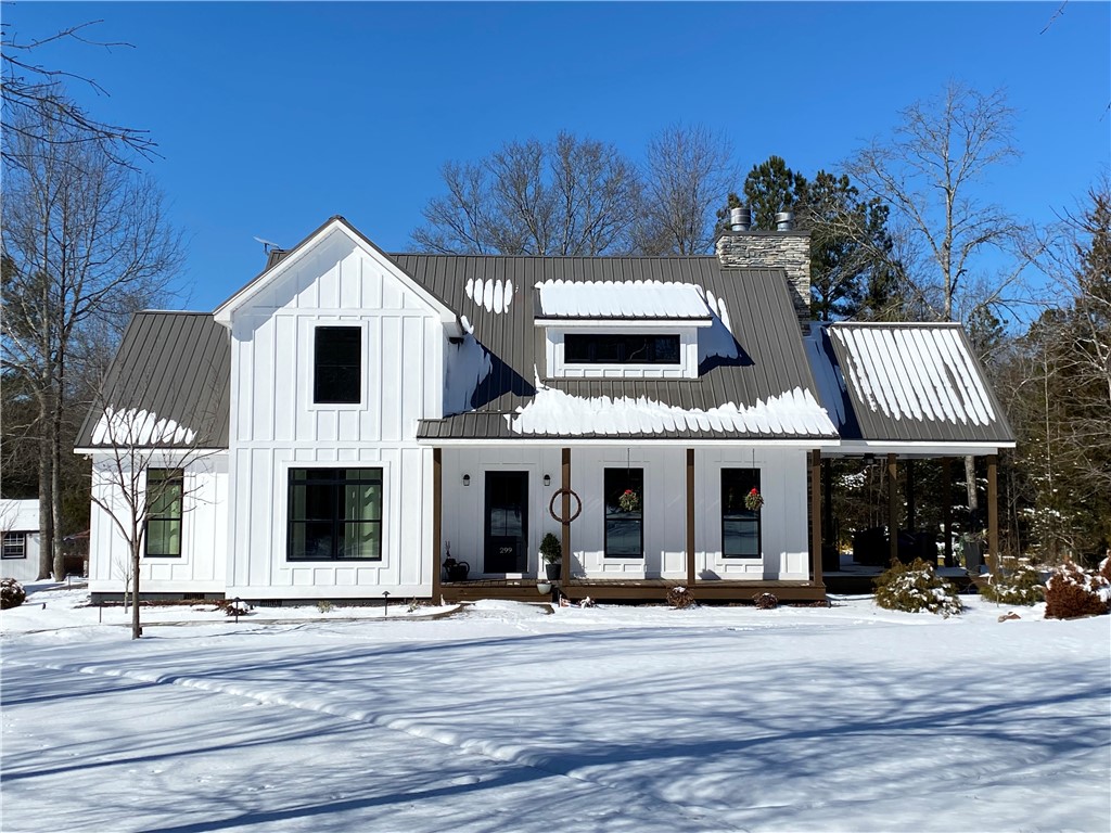 299 Scott Lane Pelzer, SC 29669 - Photo 48 of 49 This charming home features a classic white facade, complemented by a covered porch, and a metal roof.