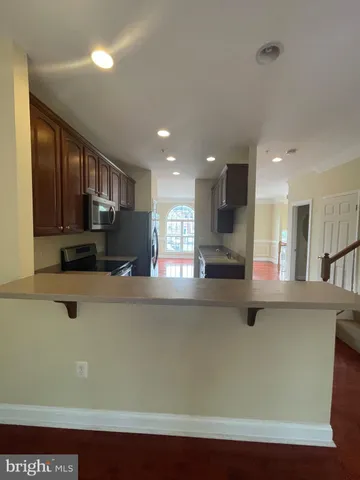 a kitchen with stainless steel appliances granite countertop a refrigerator a sink a stove and a refrigerator with wooden floor