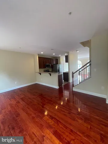 a view of a livingroom with wooden floor and a ceiling fan