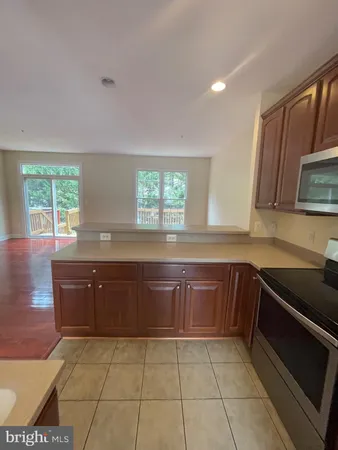 a kitchen with granite countertop a sink a stove a microwave and cabinets