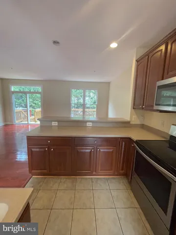 a kitchen with granite countertop a sink a stove a microwave and cabinets