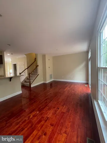 a view of empty room with wooden floor
