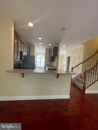 a view of kitchen with wooden floor and stairs