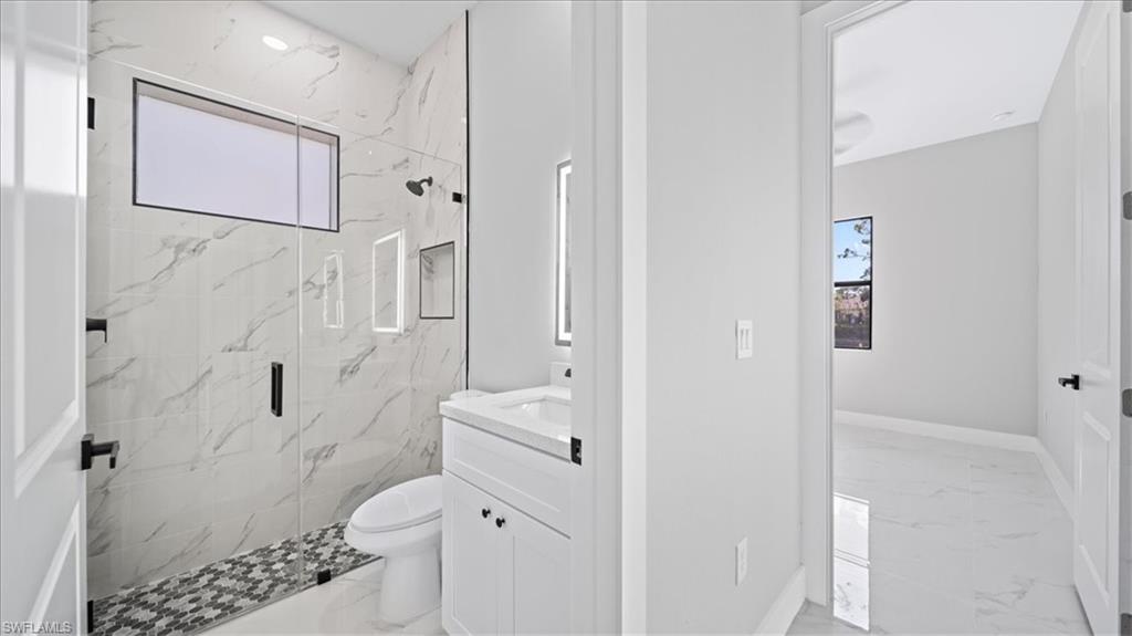 926 Winters Street East Lehigh Acres, FL 33974 - Photo 21 of 36 a bathroom with a shower toilet and sink