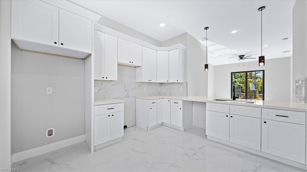 926 Winters Street East Lehigh Acres, FL 33974 - Photo 26 of 36 a large white kitchen with white cabinets
