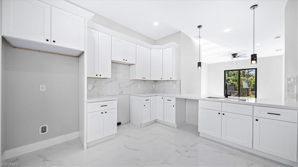 926 Winters Street East Lehigh Acres, FL 33974 - Photo 29 of 36 a kitchen with white cabinets and white appliances