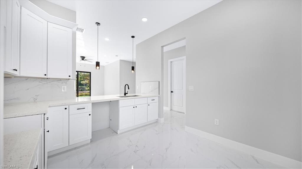 926 Winters Street East Lehigh Acres, FL 33974 - Photo 30 of 36 a large white kitchen with white cabinets