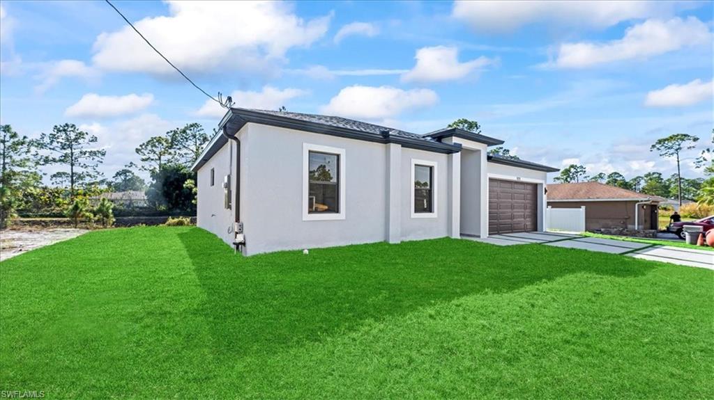 926 Winters Street East Lehigh Acres, FL 33974 - Photo 3 of 36 a view of a backyard with plants and a big yard