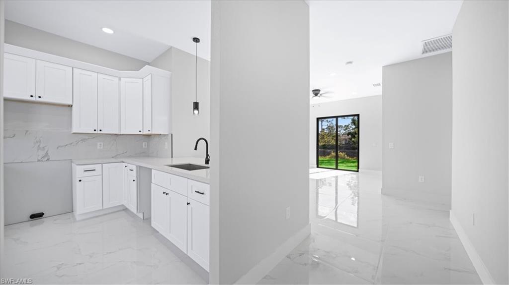 926 Winters Street East Lehigh Acres, FL 33974 - Photo 32 of 36 a kitchen with white cabinets and sink