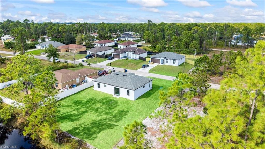 926 Winters Street East Lehigh Acres, FL 33974 - Photo 35 of 36 an aerial view of a house with a garden and lake view
