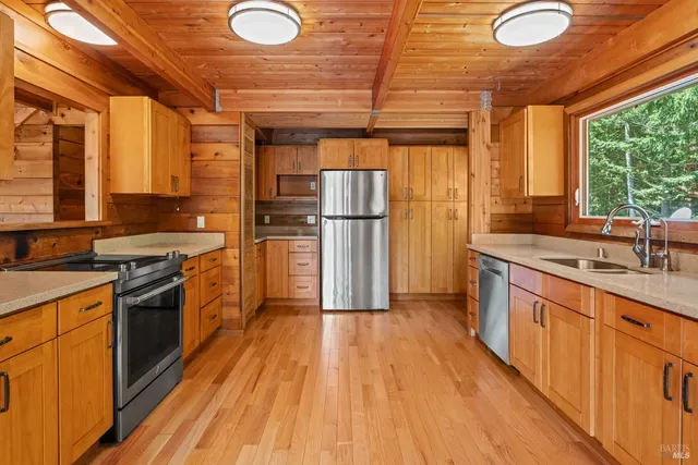a kitchen with wooden floors and stainless steel appliances