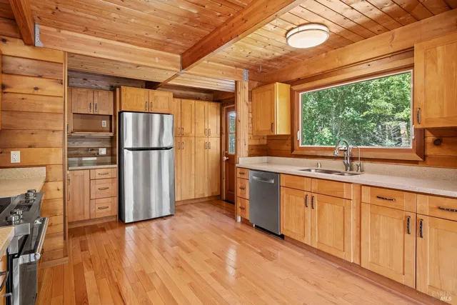 a kitchen with stainless steel appliances granite countertop a refrigerator and a sink
