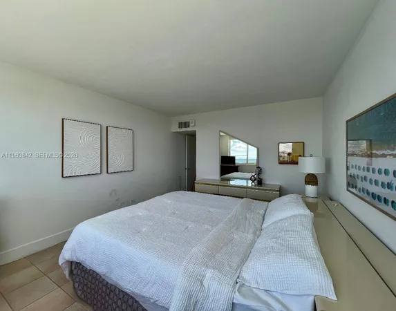 a bedroom with a bed and a night stand