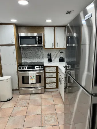 a kitchen with a stove a refrigerator and a microwave