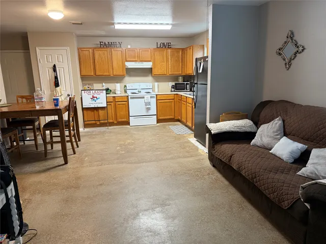 a living room with furniture and a kitchen