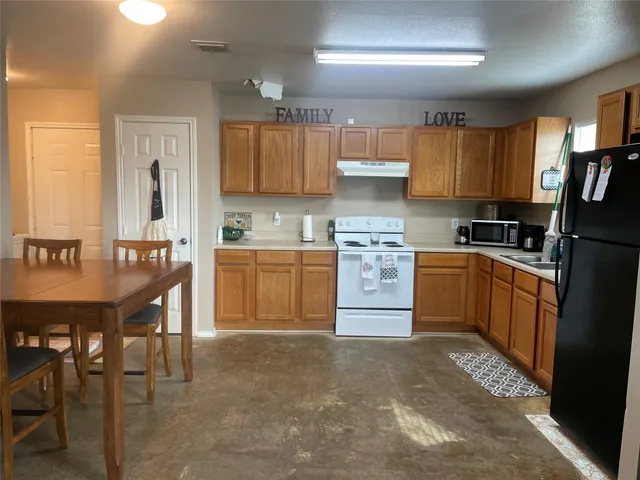 a kitchen with a sink a stove and chairs