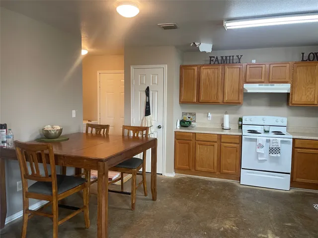 a kitchen with a table chairs sink and cabinets
