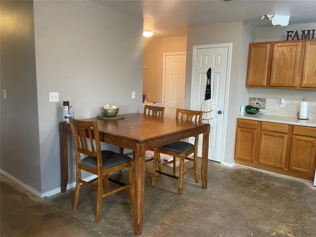 a dining room with a wooden table and chairs
