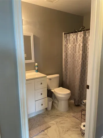 a bathroom with a toilet sink and a mirror