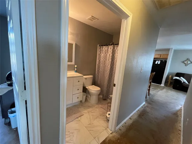 a view of a hallway with toilet and a door