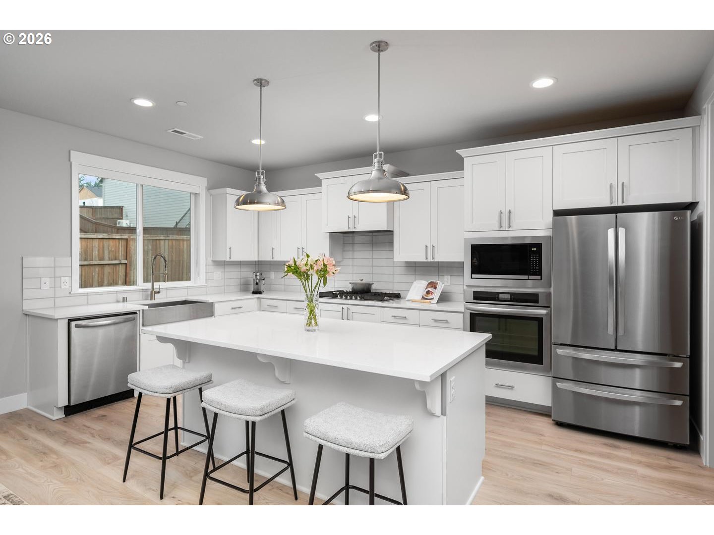 5489 North 91st Avenue Camas, WA 98607 - Photo 13 of 44 a kitchen with stainless steel appliances kitchen island granite countertop a refrigerator a sink dishwasher a stove and white cabinets with wooden floor
