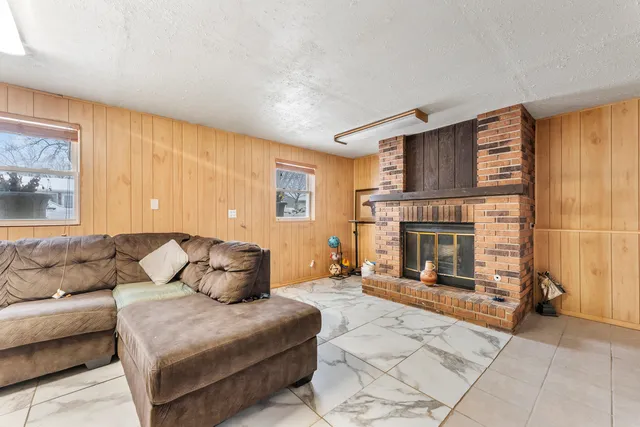 a living room with furniture a fireplace with a large window